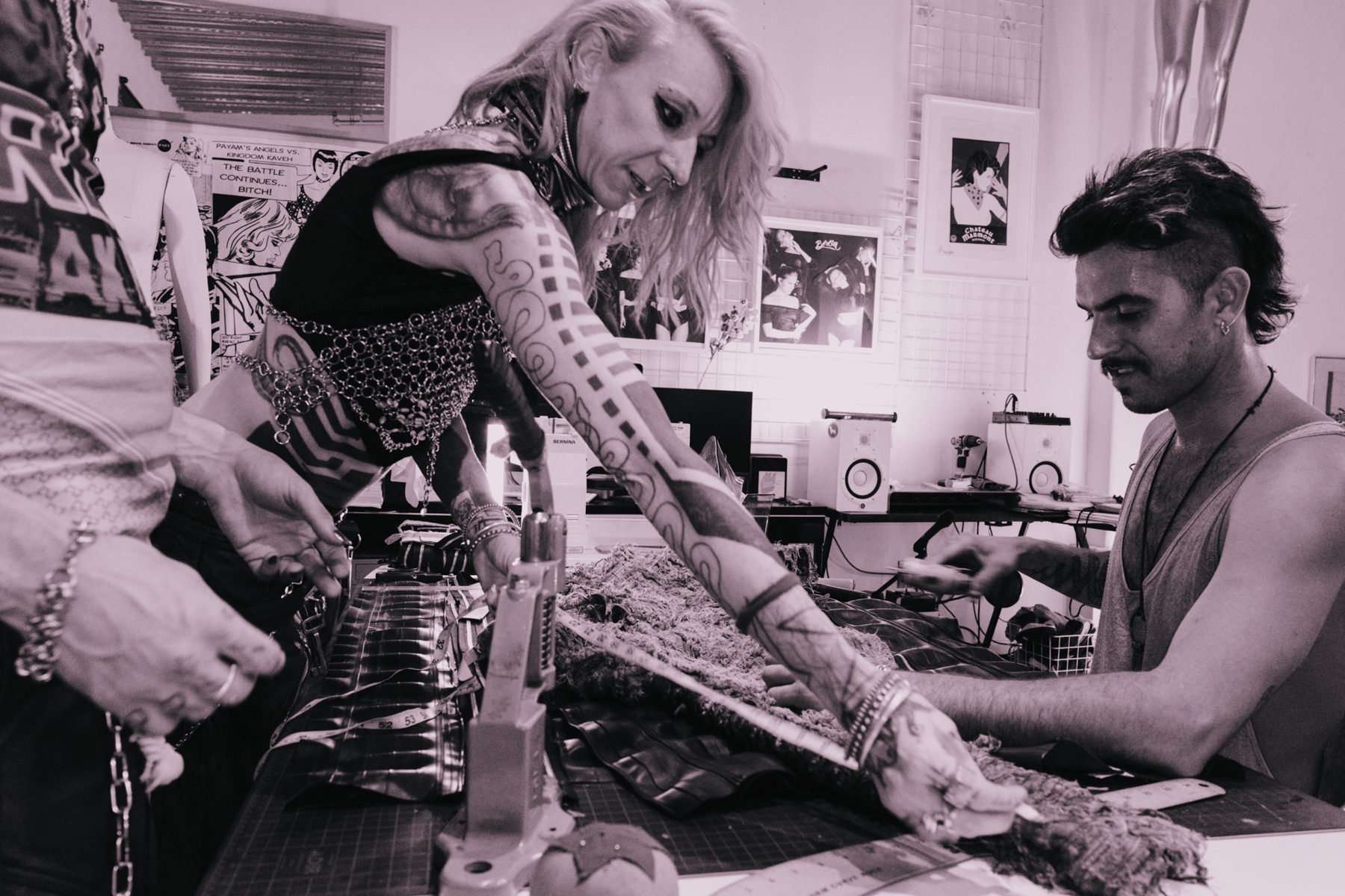 Two designers measuring a shredded sleeve across the cutting table