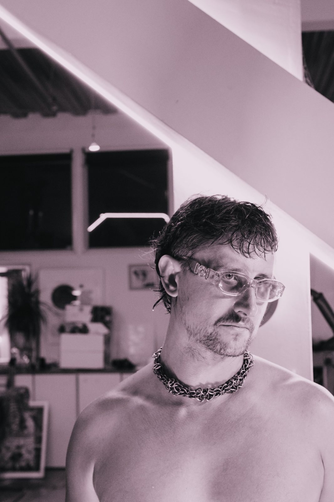 Designer in clear glasses and a chainmail collar
