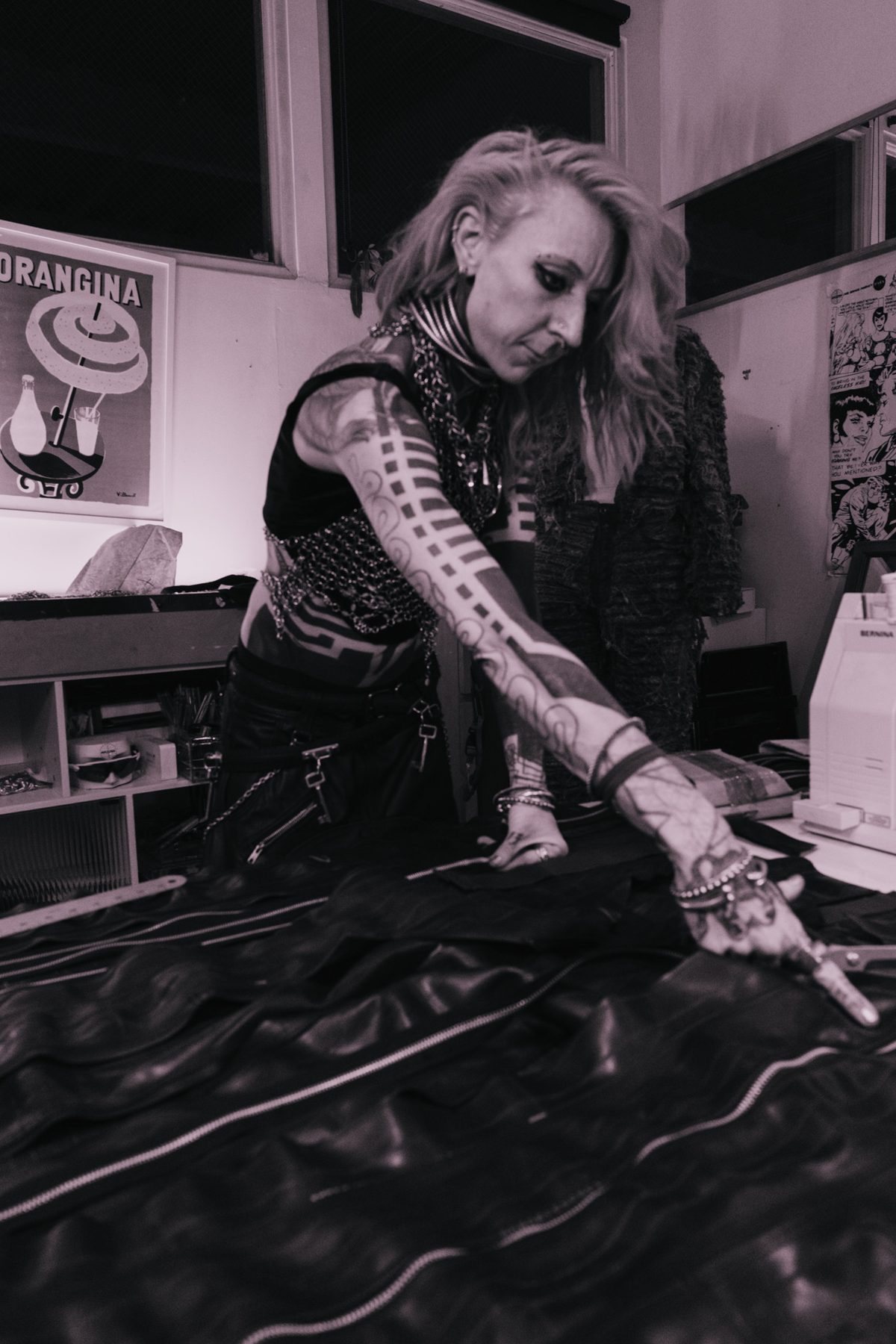 Designer cutting black leather with scissors