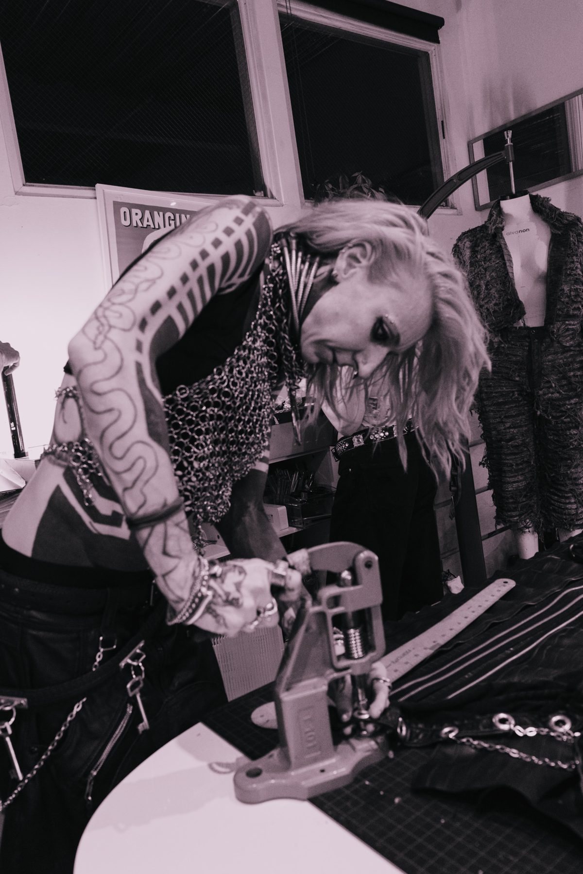 Designer setting rivets into leather with a hand press